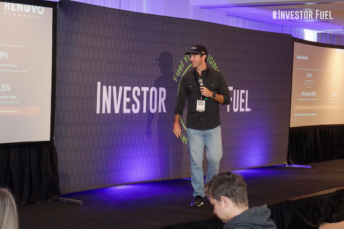A member presenting on stage at an Investor Fuel Mastermind